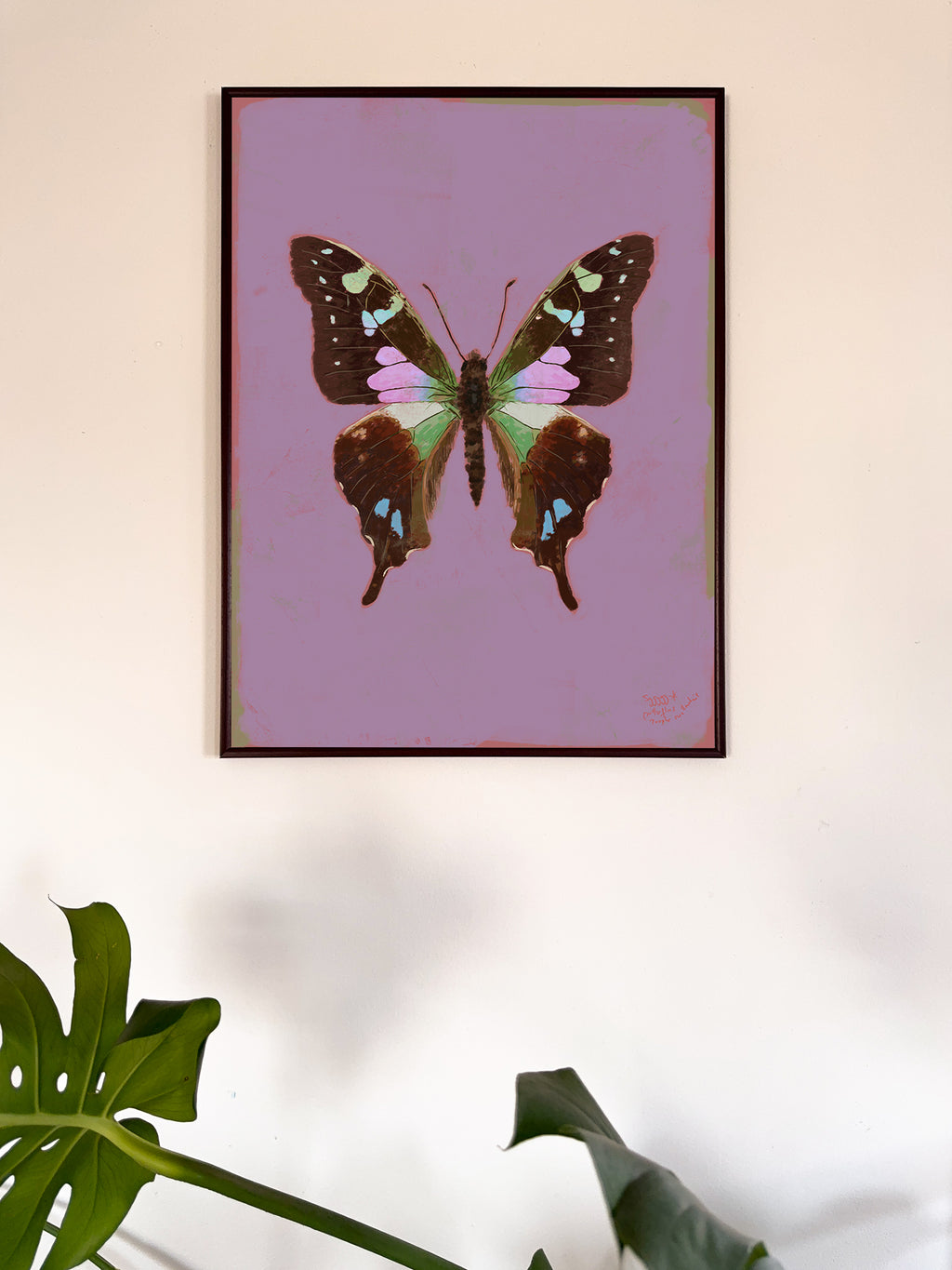 Framed artwork of a butterfly on a purple background, with a plant in the foreground.