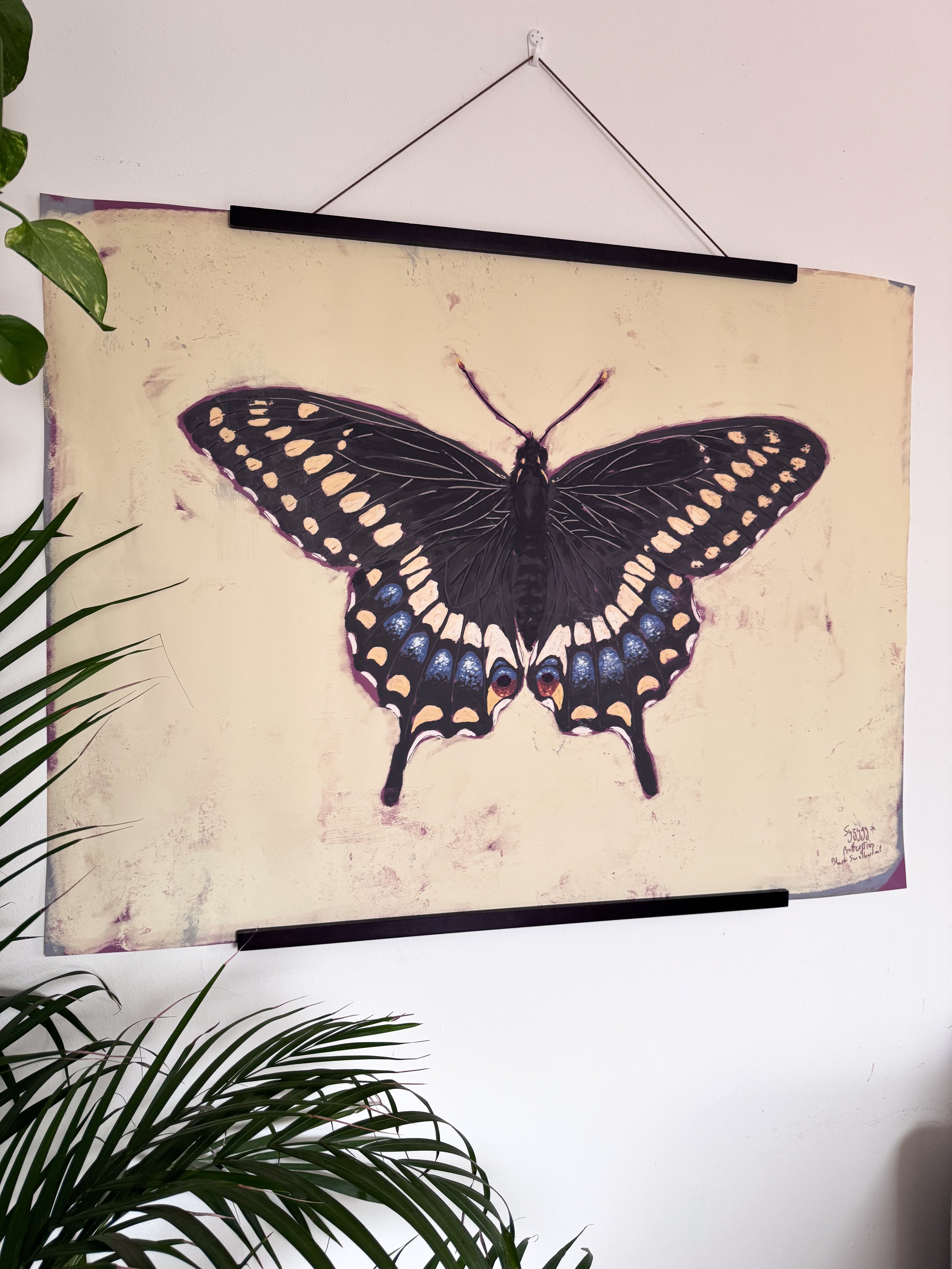 Butterfly artwork on a pale yellow background with a plant in the foreground