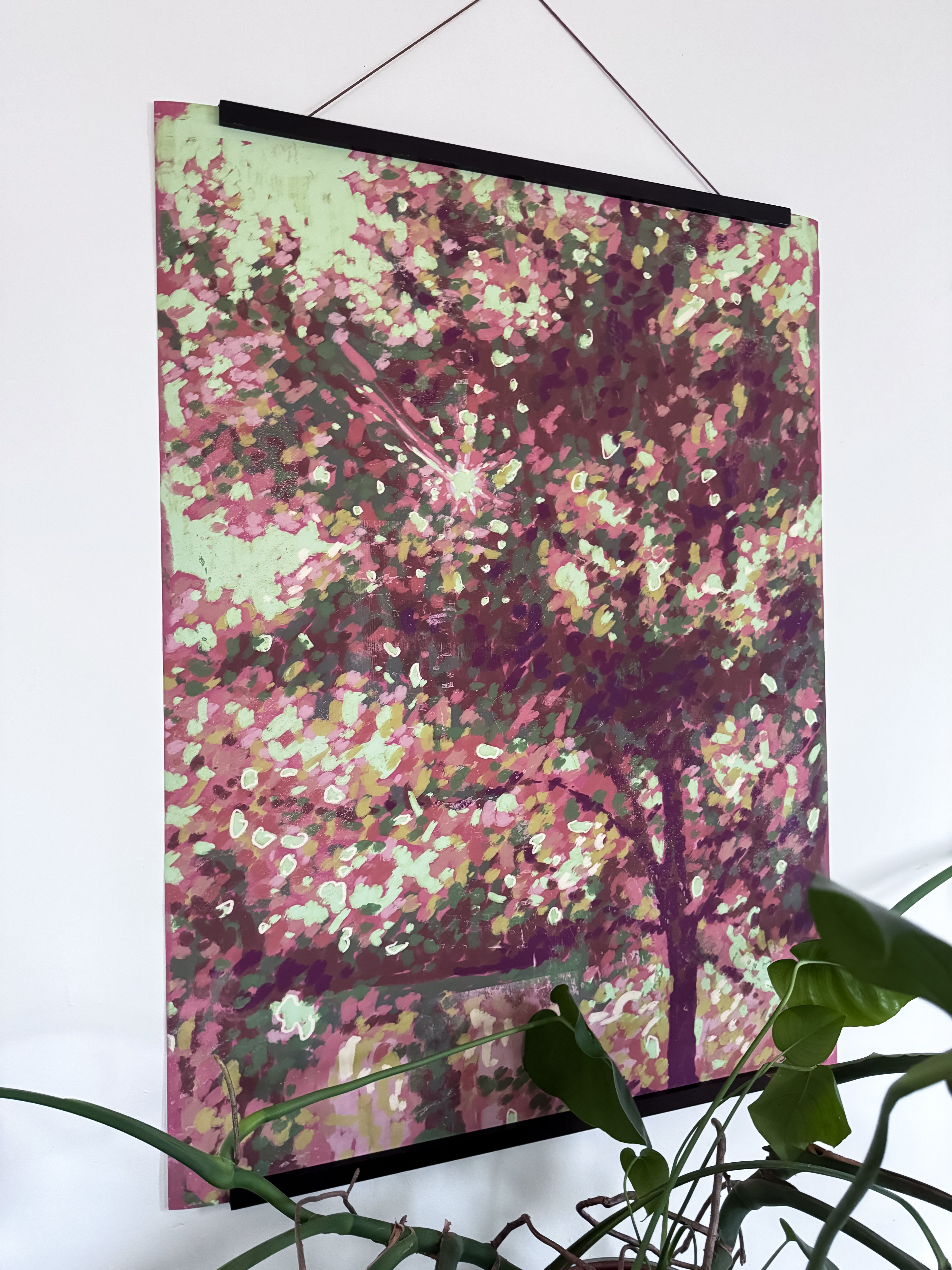 Artwork with hanger of a colorful impressionist tree on a white wall