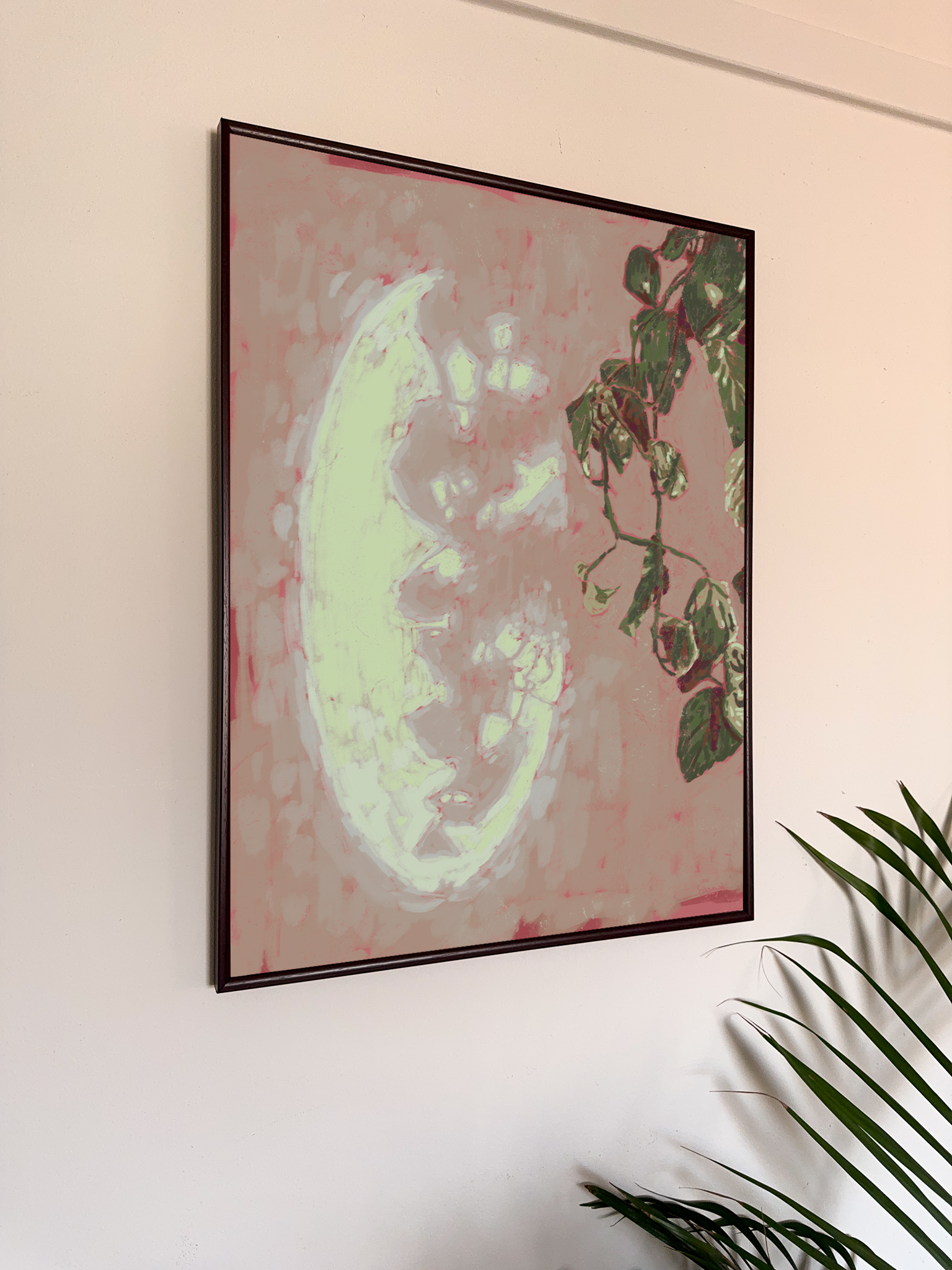 Framed artwork with a plant design on a wall, featuring a plant in the foreground.