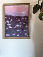 Impressionistic art print of a purple floral field, framed on a white wall