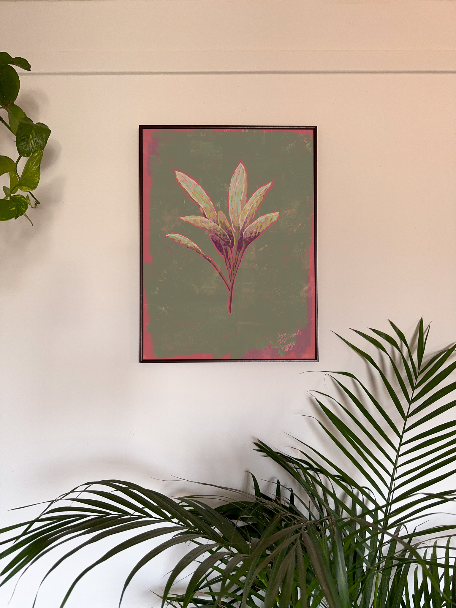 Framed botanical art on a wall with plants around
