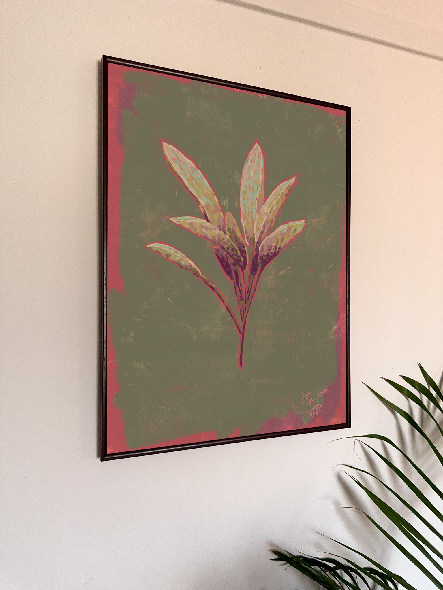 Framed botanical art of a sage leaf on a wall with a plant in the corner.