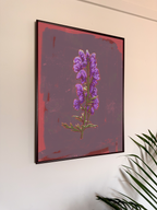 Framed artwork of a purple flower on a wall with a plant in the corner.