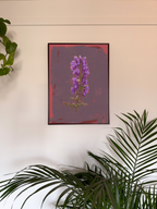 Framed artwork of a purple flower on a white wall with green plants.