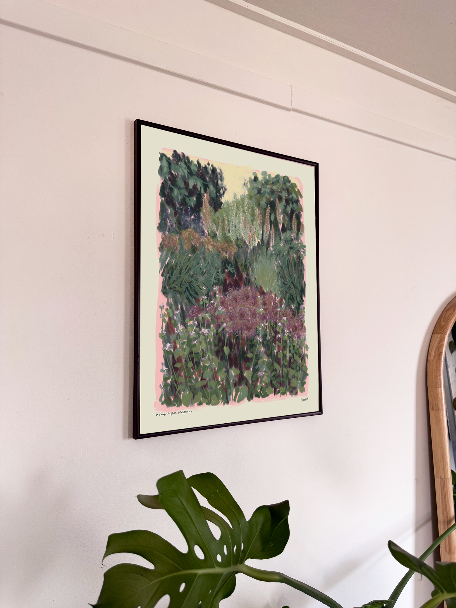 Framed artwork on a wall with a plant in the foreground