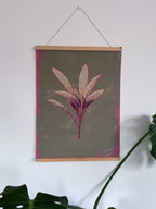Floral sage artwork with pink leaves in a wooden magnetic frame hanging on a white wall.