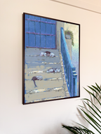 Framed artwork of cats lying on a staircase with the sea in background displayed on a wall.