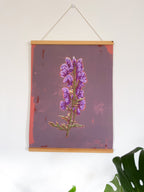 Artwork with magnetic hanger of a purple flower on a white wall